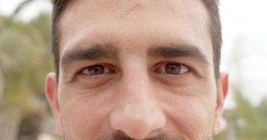 Kumsalda kameraya bakan mutlu beyaz adamın portresi. Tatil, boş zaman, yaz ve yaşam tarzı.