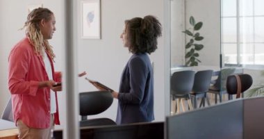 Tablet kullanan ve ofiste ağır çekimde konuşan çeşitli iş arkadaşlarınız kutlu olsun. Günlük ofis, iş, takım çalışması ve yaratıcı çalışma.