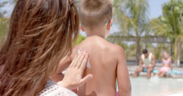 Glückliche Kaukasische Mutter Benutzt Sonnencreme Für Ihren Sohn Schwimmbad Urlaub — Stockvideo