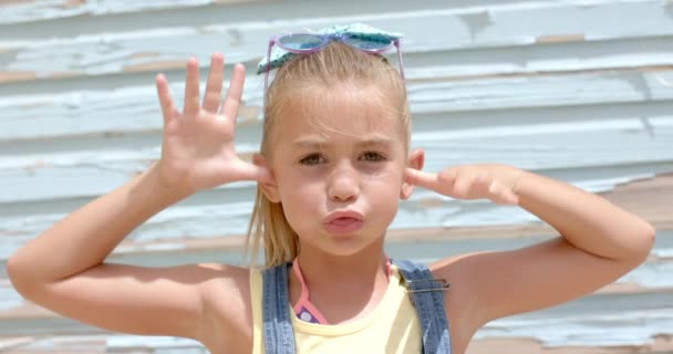 Портрет Щасливої Кавказької Дівчини Робить Обличчя Руками Над Пляжним Будинком — стокове відео