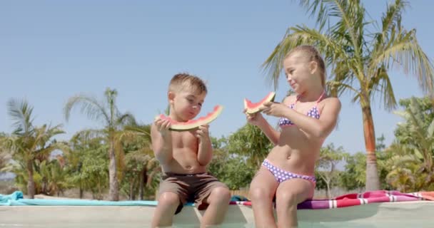 Glückliche Kaukasische Geschwister Essen Wassermelone Swimmingpool Strandhaus Urlaub Freizeit Sommer — Stockvideo
