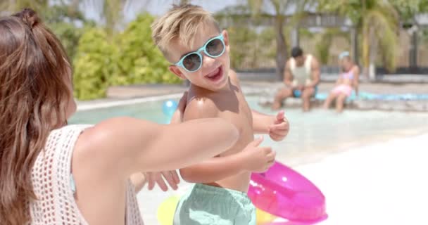 Glückliche Kaukasische Mutter Benutzt Sonnencreme Für Ihren Sohn Schwimmbad Urlaub — Stockvideo