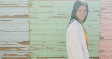 Solgun ahşap duvarın önünde gülümseyen İspanyol kadının portresi, fotokopi uzayı, ağır çekim. Yaz, dinlenme ve tatiller.