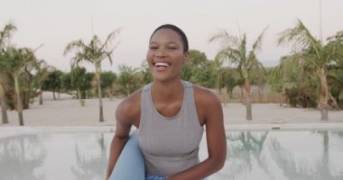 Sahilde yoga yaptıktan sonra hasıraltı edilmiş gülümseyen melez kadın portresi, ağır çekimde. Yaz, rahatlama, sağlıklı yaşam tarzı ve tatiller..