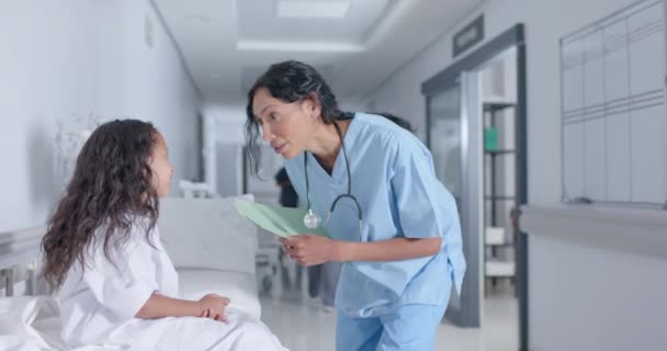 不同的女医生和儿童患者在医院走廊里慢吞吞地交谈 医药和保健 — 图库视频影像
