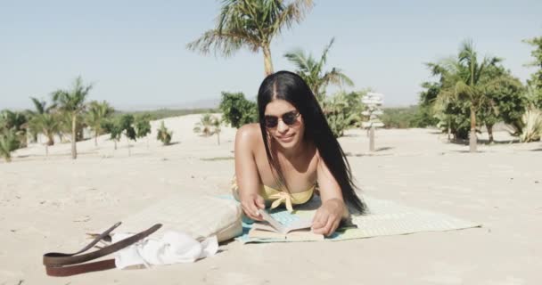 Glad Latinamerikansk Kvinna Solglasögon Liggande Stranden Läser Bok Solen Slow — Stockvideo
