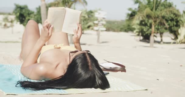 Hispanic Kvinna Solglasögon Liggande Stranden Läsa Bok Kopiera Utrymme Slow — Stockvideo