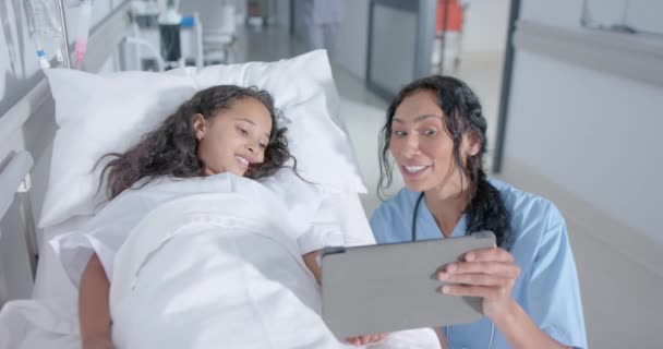 Διαφορετική Γυναίκα Γιατρός Και Παιδί Ασθενή Χρησιμοποιώντας Δισκίο Στο Διάδρομο — Αρχείο Βίντεο