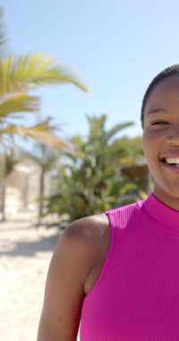 Mutlu Afro-Amerikan kadının plaj evindeki portresinin dikey videosu. Tatil, boş zaman, yaz ve yaşam tarzı.
