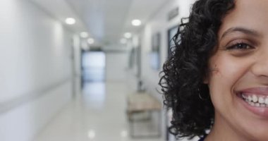 Hastanede ağır çekimde mutlu çift ırklı kadın doktor portresi. İlaç, sağlık ve bakım.