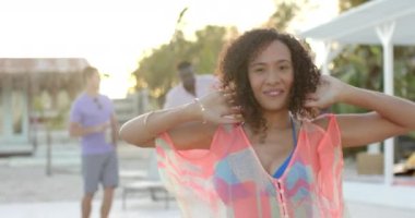 Sahilde arkadaşlarıyla dans eden mutlu melez kadın portresi. Tatil, boş zaman, yaz ve arkadaşlık.