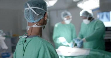 Ameliyathanede ağır çekimde ameliyat sırasında yüz maskesi takan çeşitli cerrahların portresi. İlaç, sağlık ve bakım.