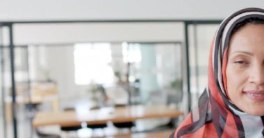 Çift ırklı mutlu iş kadınının portresi ofiste ağır çekimde tesettürlü. Günlük iş, iş ve güven.