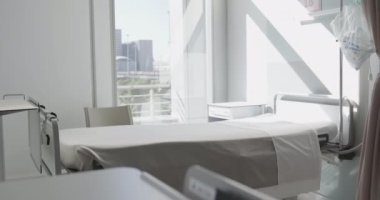 Hastane yatağı ve penceresi olan boş bir hasta odası manzarası. Tıp ve iç mekan.