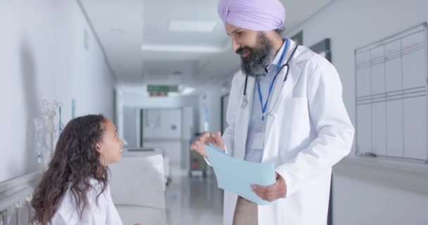 病院のスローモーションで廊下でターバンや小児患者高5の多様なシフト男性医師 — ストック動画