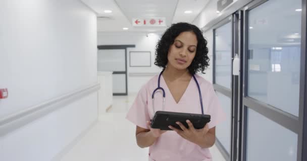Médica Birracial Focada Andando Usando Tablet Hospital Câmera Lenta Medicina — Vídeo de Stock