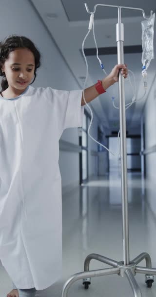 Vídeo Vertical Retrato Menina Feliz Biracial Andando Com Gotejamento Hospital — Vídeo de Stock