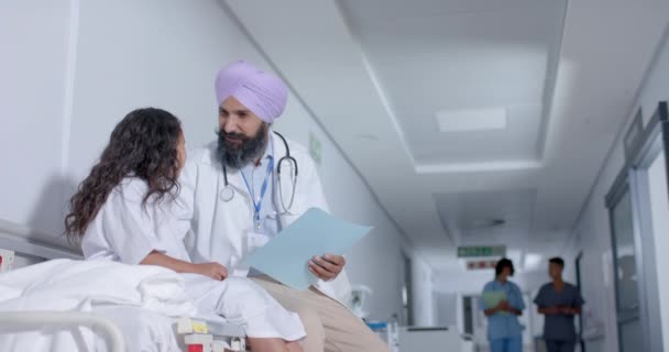 ターバンの多様なシフト男性医師と小児患者は ゆっくりと動き 病院の廊下で話しています — ストック動画