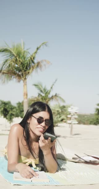 Vídeo Vertical Mulher Biracial Feliz Falando Smartphone Deitado Praia Sol — Vídeo de Stock
