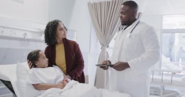 Hasta kızıyla hastanede ağır çekimde doktorla konuşan çok yönlü bir annesi var. İlaç, sağlık ve bakım.