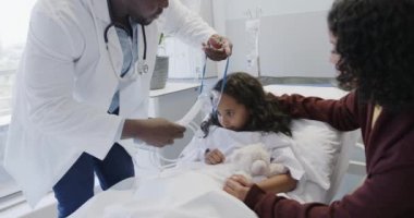 Çeşitli doktorlar, annesi ağır çekimde olan hasta kıza oksijen maskesi takıyor. İlaç, sağlık ve bakım.
