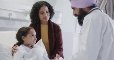 Annesi ağır çekimde hastanede olan hasta bir kız üzerinde solunum cihazı kullanan mutlu çift ırklı bir doktor. İlaç, sağlık ve bakım.