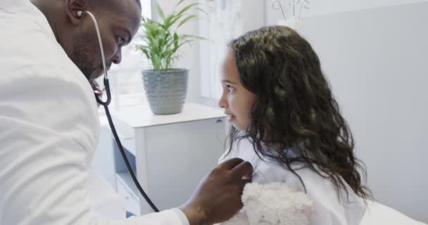 Szczęśliwy Zróżnicowany Lekarz Badający Chorego Pacjenta Dziewczyny Stetoskopem Szpitalu Zwolnionym — Wideo stockowe