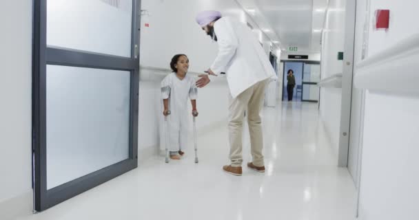 Szczęśliwy Dwurasowy Lekarz Chodzący Rozmawiający Chorą Pacjentką Kulami Zwolnionym Tempie — Wideo stockowe