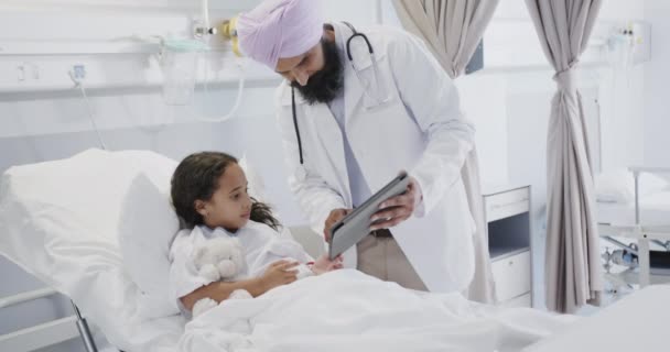 遅い動きで病院のベッドで病気の女の子の患者とタブレットを使用して幸せな出産の医者 — ストック動画
