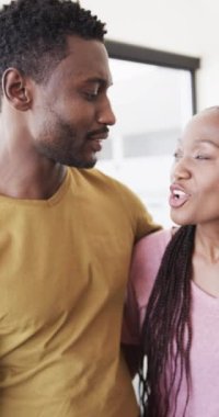 Yavaş çekimde evde kucaklaşan mutlu Afrikalı Amerikalı çiftin dikey videosu. Ev hayatı, yaşam tarzı ve aşk..