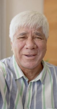 Kafkasyalı bir adamın yavaş çekimde videoya çekilen portresinin dikey videosu. Emeklilik, yaşam tarzı ve teknoloji.