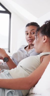 Çift ırklı mutlu bir çiftin yatakta ağır çekimde konuştuğu dikey bir video. Ev hayatı, yaşam tarzı ve aşk..