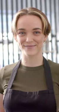 Kafkas kadın kuaförün yavaş çekimde kuaföre gülümseyişinin dikey videosu. Kuaför, güzellik ve iş.