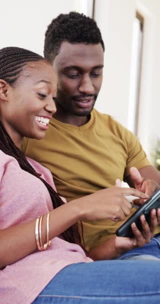 幸せなアフリカ系アメリカ人のカップルの垂直ビデオスローモーションで自宅でタブレットを使用しています 家庭生活 ライフスタイル — ストック動画