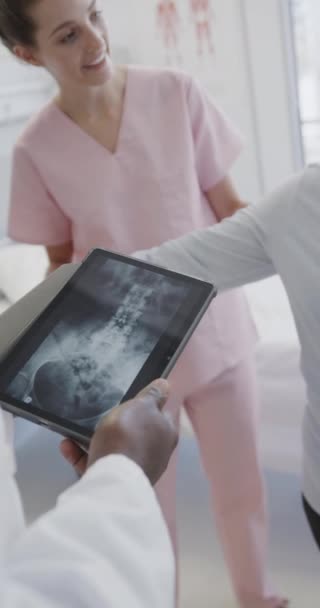 Vídeo Vertical Diverso Médico Masculino Con Tableta Fisio Femenino Paciente — Vídeos de Stock