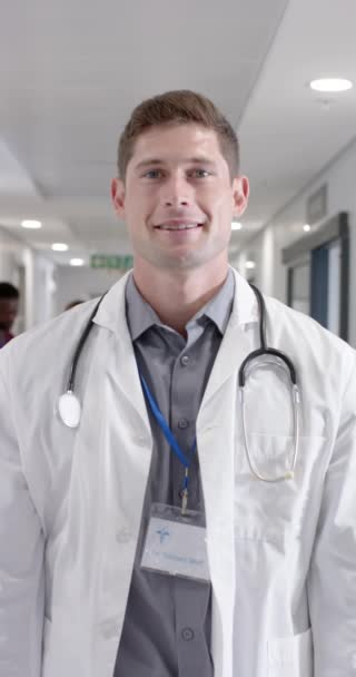 幸せな白人男性医師のスローモーションでカメラを見ての肖像画の垂直ビデオ — ストック動画