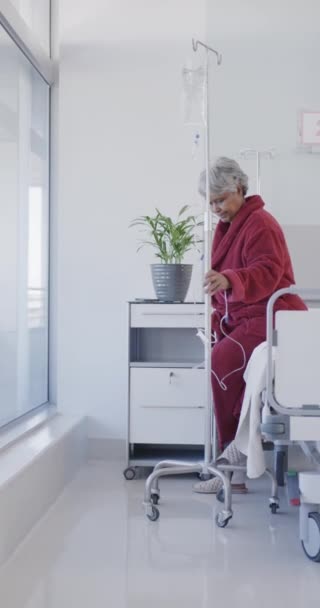 Verticale Video Van Biracial Senior Vrouwelijke Patiënt Met Druiper Lopen — Stockvideo