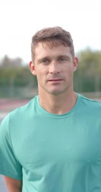 Tenis kortunda ağır çekimde mutlu beyaz adamın portresinin dikey videosu. Spor, yaşam tarzı ve etkinlik.
