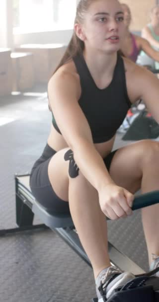 Vertical Video Diverse Sportswomen Exercising Rowing Machines Gym Slow Motion — Stock Video