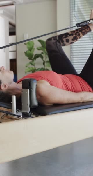 Vertical Video Senior Caucasian Woman Stretching Reformer Pilates Studio Slow — Stock Video