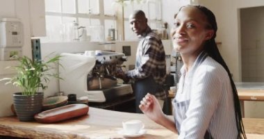 Kafede gülümseyen Afro-Amerikan erkek ve kadın baristaların portresi, ağır çekimde. Yaşam tarzı, girişimcilik ve yerel işletme.