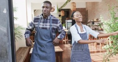 Kafede gülümseyen Afro-Amerikan erkek ve kadın baristaların portresi, ağır çekimde. Yaşam tarzı, girişimcilik ve yerel işletme.