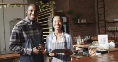 Kafede gülümseyen Afro-Amerikan erkek ve kadın baristaların portresi, ağır çekimde. Yaşam tarzı, girişimcilik ve yerel işletme.