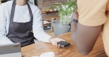 Afro-Amerikalı bir adam kahvecide ağır çekimde ukalalık yaparak ödeme yapıyor. Yaşam tarzı, teknoloji, girişimcilik ve yerel işletme.