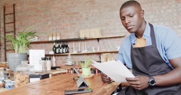 African American Male Barista Using Tablet Holding Documents Coffee Shop — Stock Video