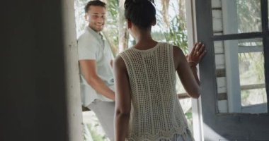 Güneşli sahil evinde yavaş çekimde konuşan ve kucaklaşan mutlu çift. Rahatlama, romantizm, tatiller ve yaşam tarzı.