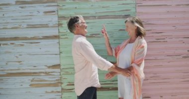 Siyahi yıpranmış ahşap duvarlar tarafından ağır çekimde kucaklanan mutlu Kafkasyalı çift. Emeklilik, romantizm, rahatlama, tatiller ve yaşlı yaşam tarzı.