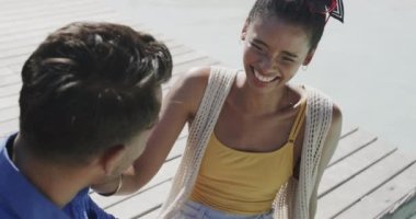 Mutlu çift konuşuyor ve gülüyor. Güneş güvertesinde havuz başında oturuyor, ağır çekimde. Rahatlama, romantizm, tatiller ve yaşam tarzı.