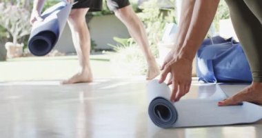 Değişik yaşlıları yavaş çekimde pilates sınıfı için egzersiz paspasları hazırlarken kapatın. Egzersiz, emeklilik ve sağlıklı bir yaşam tarzı..