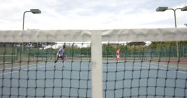 İki farklı erkek arkadaş, açık sahada ağır çekimde ikili top oynuyorlar. Spor, arkadaşlık, takım çalışması, eğlence, hafta sonu, yaşam tarzı ve etkinlik.